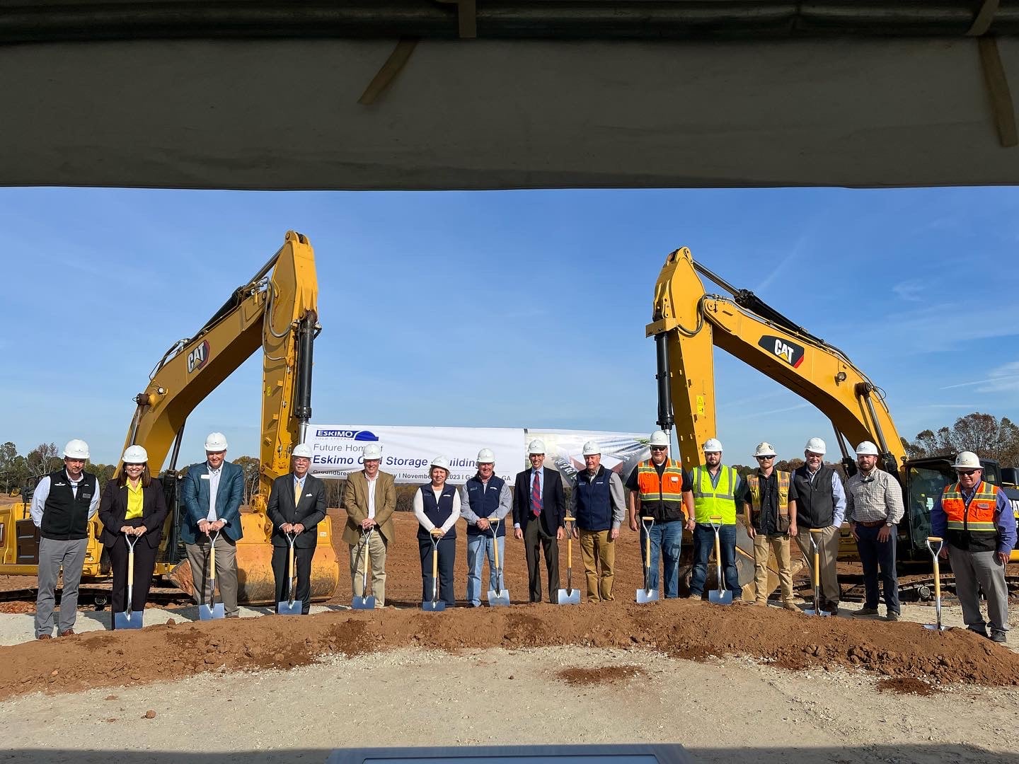 Project team standing in front of banner at groundbreaking ceremony